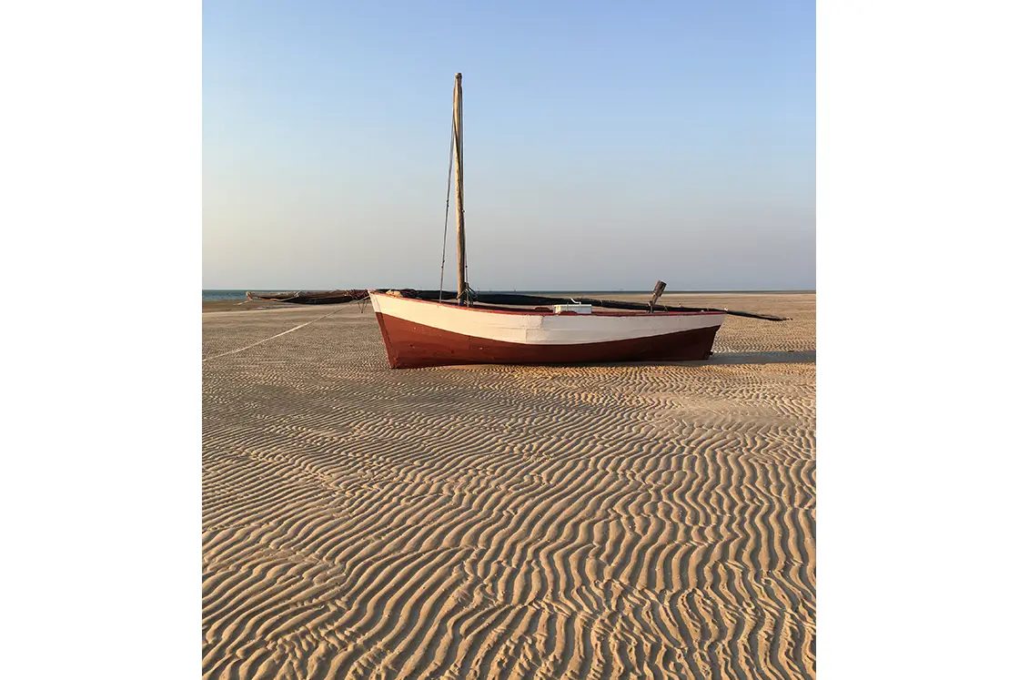 Perfect Hideaways real estate property: A sailboat resting on the sand, showcasing the patterns made in the sand by the wind. The Sanctuary Private Reserve, Mozambique.