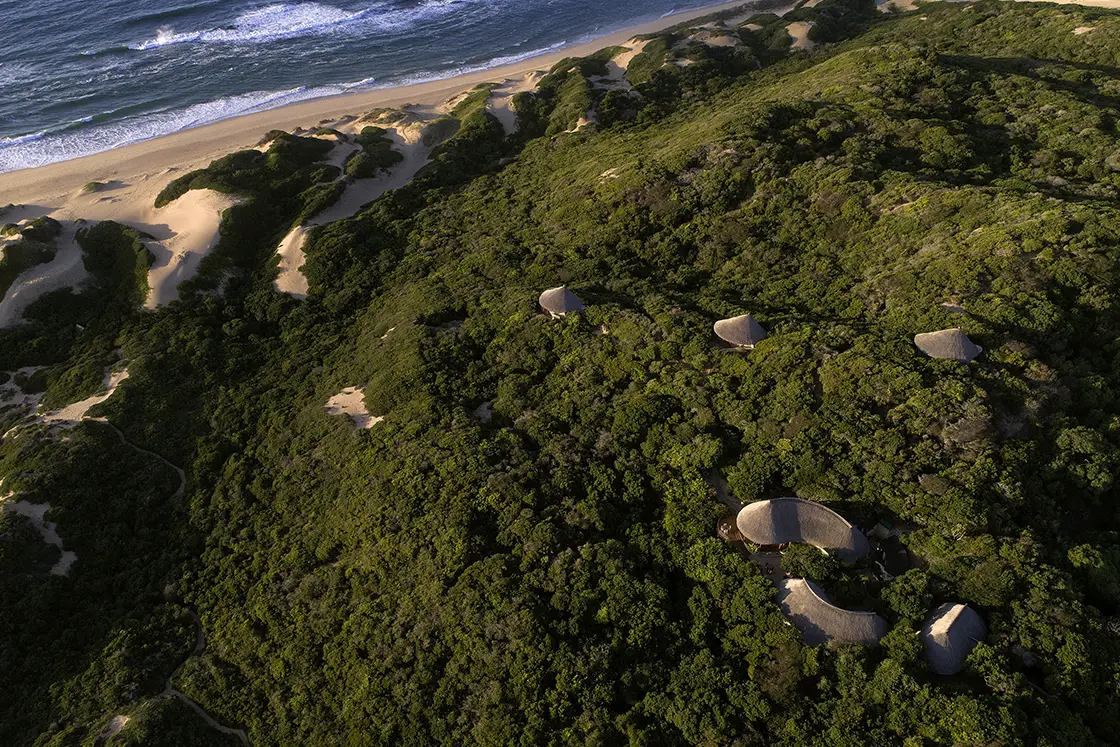 Perfect Hideaways real estate property: An aerial view of the lodges from above with the beach in front and uninhabited land all around. Dunes de Dovela Lodge, Mozambique.