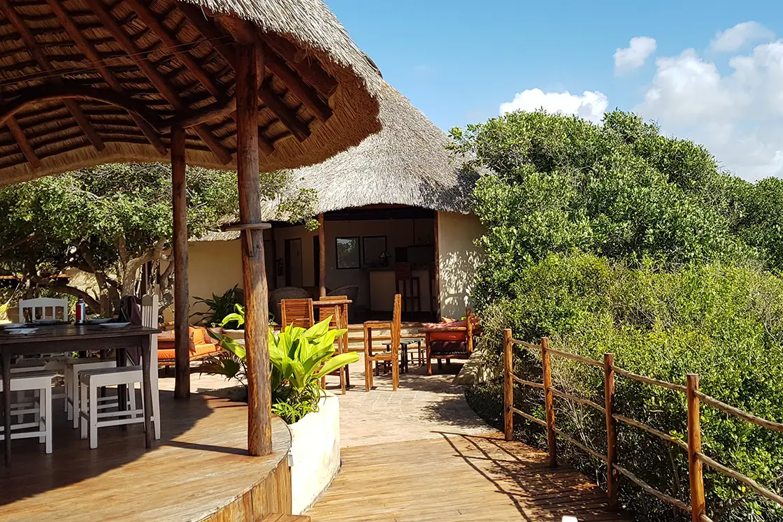 Perfect Hideaways real estate property: The main lodge has a wooden deck and dining areas on the raised platform with surrounding bushes. Dunes de Dovela Lodge, Mozambique.