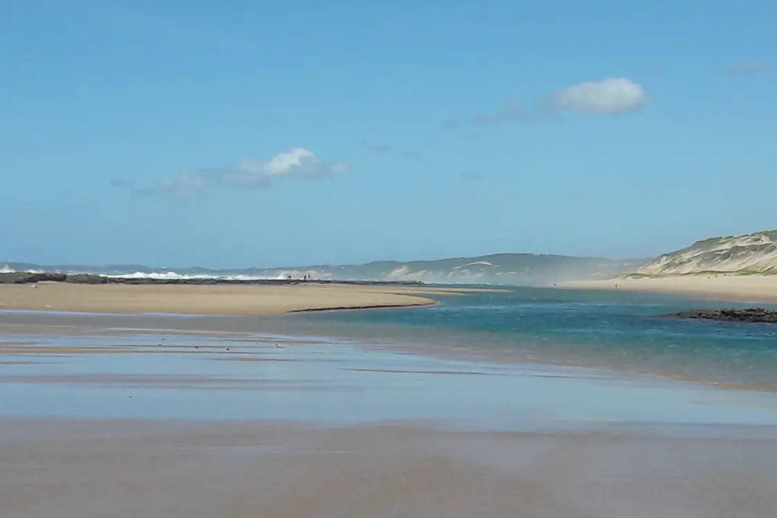 Perfect Hideaways real estate property: A beach at high tide with the water coming into a lagoon, on the horizon the dunes and bay stretch out. Dunes de Dovela Lodge, Mozambique.