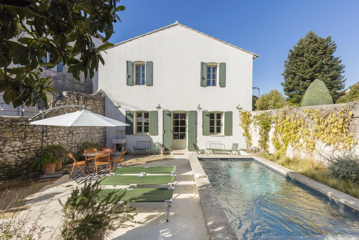 Perfect Hideaways property for sale: The outdoor terrace of a villa, which features a sparkling swimming pool beside an outdoor seating area with comfortable chairs and wall vines surrounding the terrace. France, Villa Sancti.