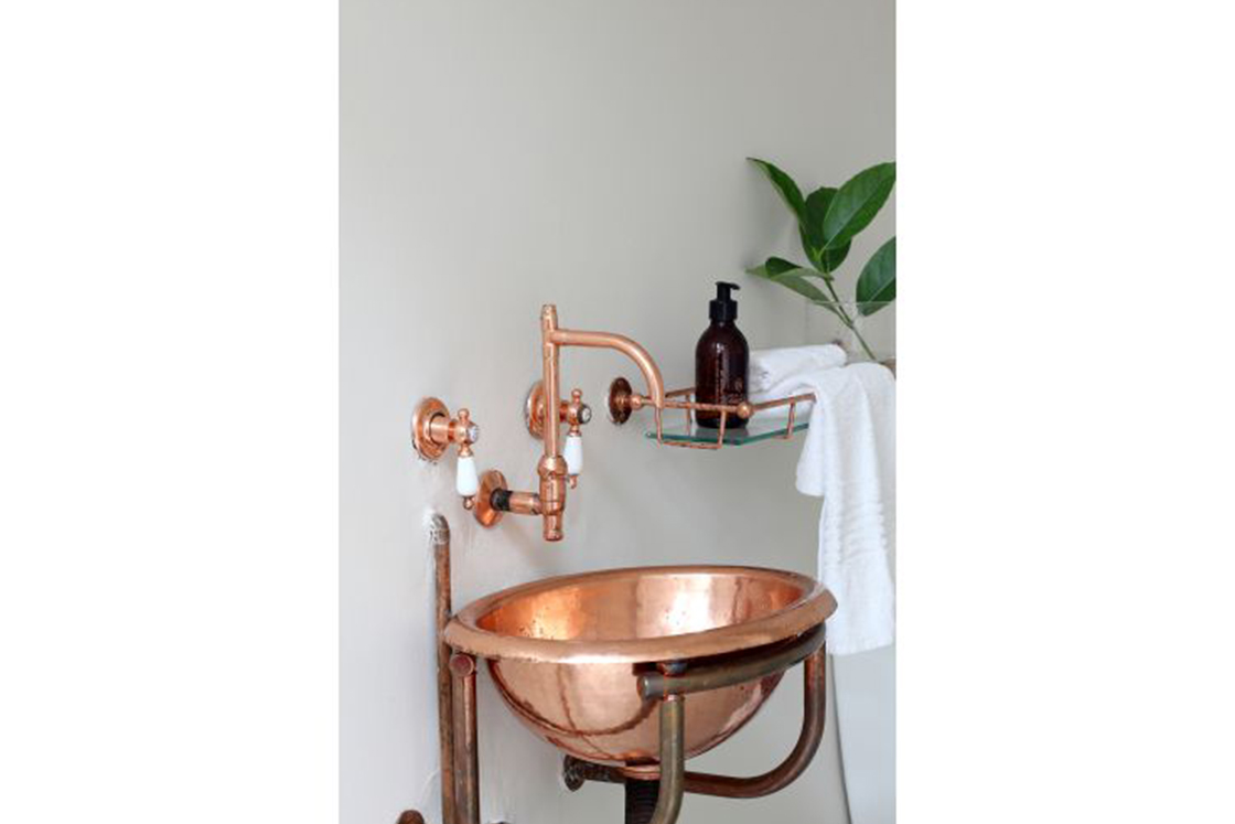 En-suite bathroom with copper finishes showcased in the basin unit, elegant spout and handles.