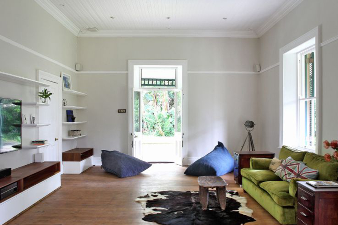 Spacious living area with contemporary decor, dark wood elements contrast the neutral tones of the Victorian style heritage home.