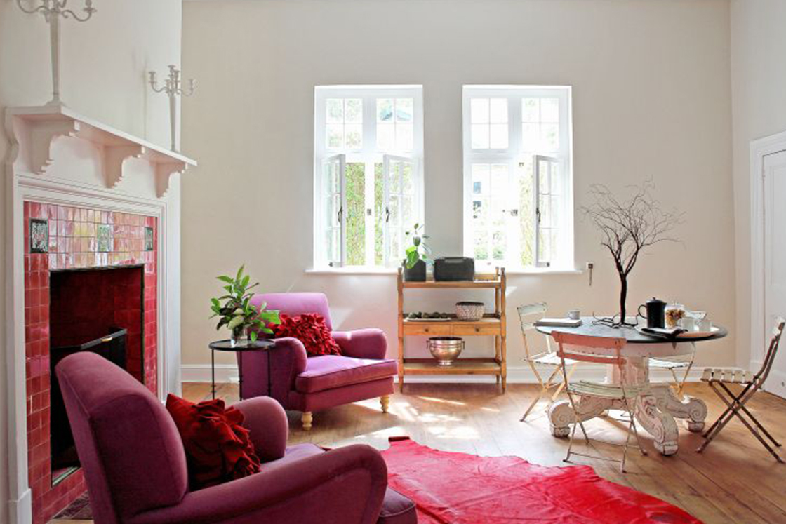 Living room with Victorian character showcasing ruby-tiled fireplace and neutral room color, which highlights the home's heritage architecture.