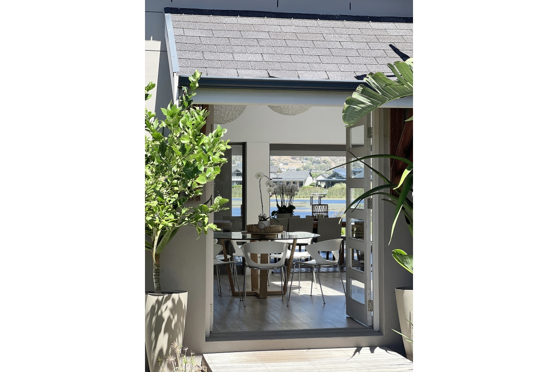 The entrance to an elegant home with a spacious patio and a table.