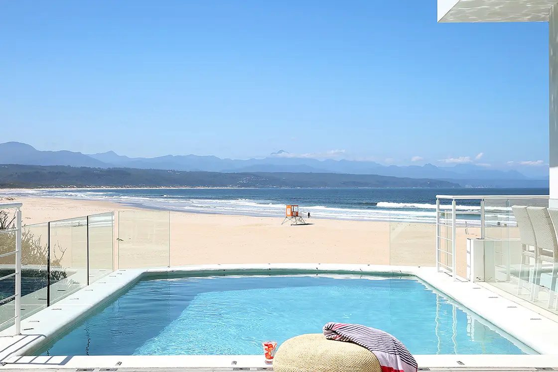 Perfect Hideaways real estate property: A poolside deck overlooking a long stretch of beach in Plettenberg Bay. Roga Rock, Plettenberg Bay.