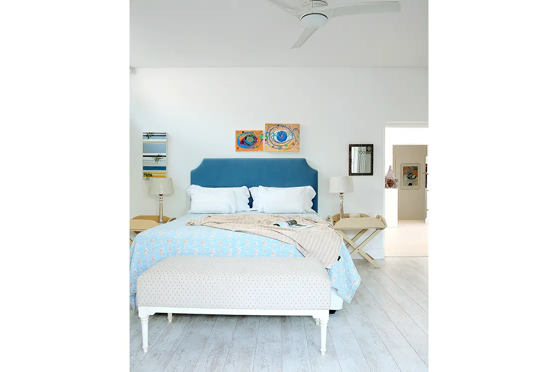 Perfect Hideaways real estate property: A bedroom area with a double bed, featuring blue tones in the bedding as well as the headboard, an ottoman at the foot of the bed. Roga Rock, Plettenberg Bay.