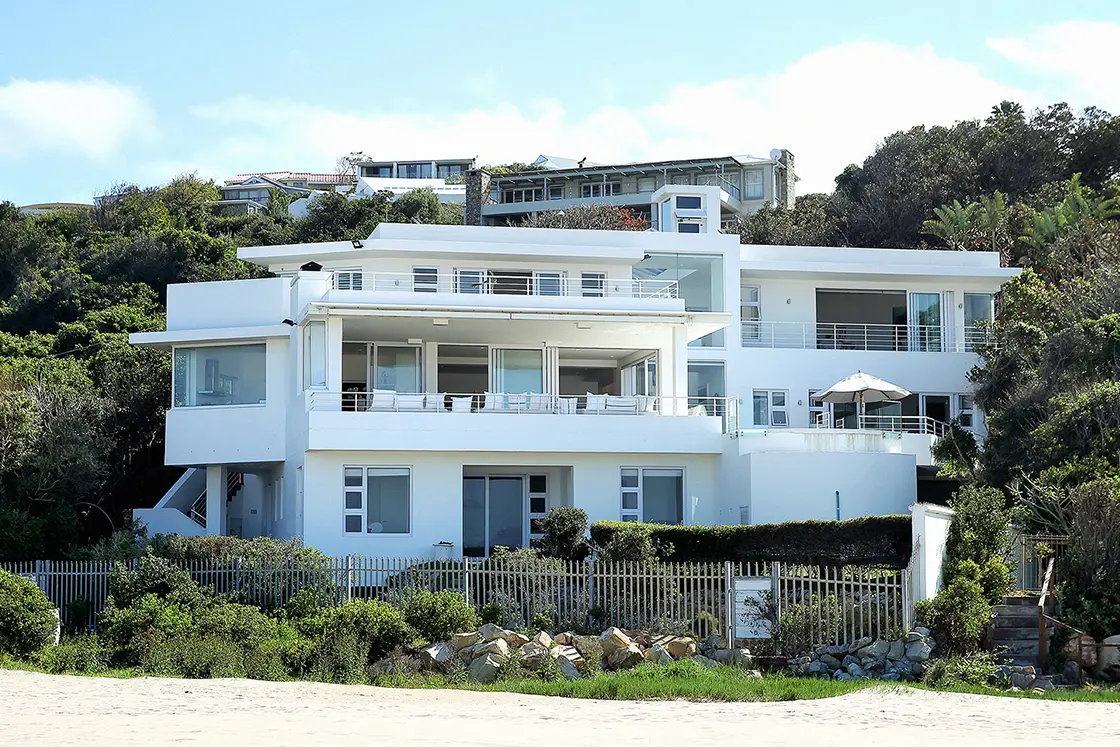 Perfect Hideaways real estate property: A three-story beach house with modern amenities, featuring multiple floors with balconies, patios, and pools. Roga Rock, Plettenberg Bay.