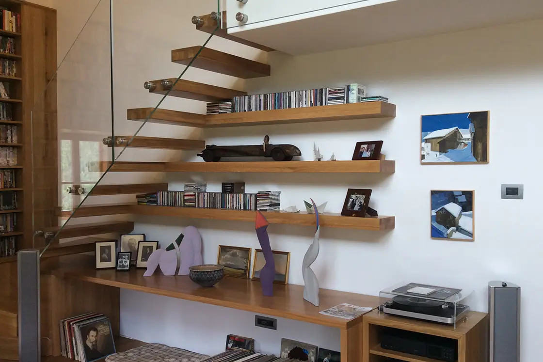 Perfect Hideaways real estate property: A bookshelf, stairway, shelving, and a storage cabinet, constructed in the same wood. Ragginerhof, Italy.