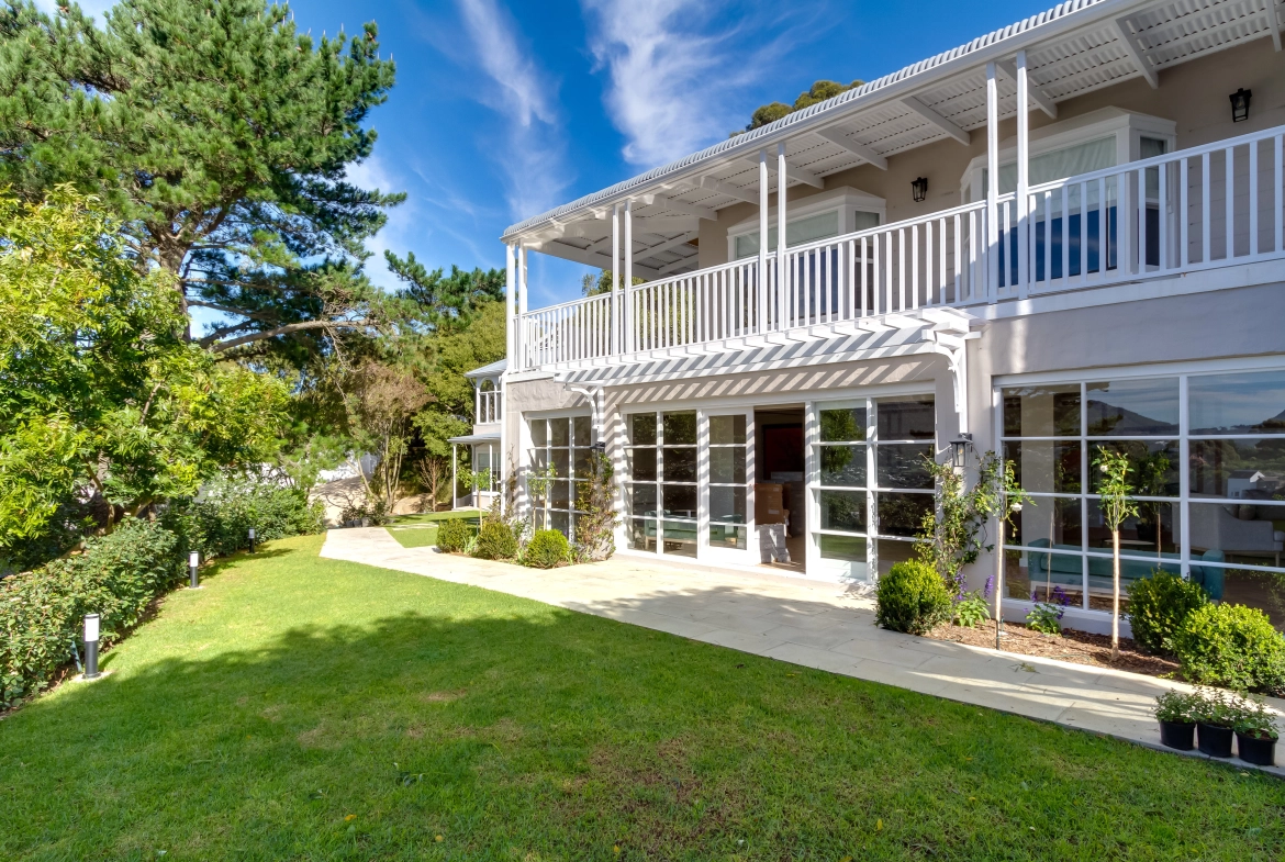 Perfect Hideaways real estate property: Double-story house with a garden, featuring French pane windows downstairs, and a sheltered upstairs balcony. The Berg Manor and Villas, Hout Bay.