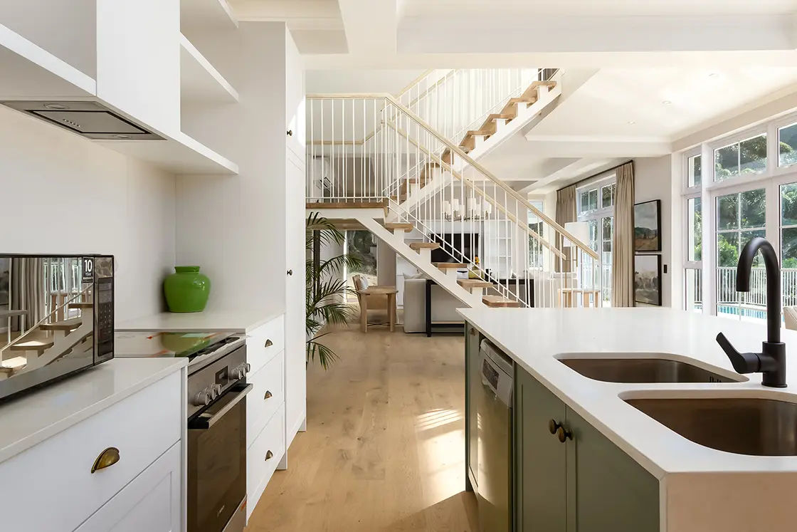 Perfect Hideaways real estate property: A contemporary kitchen and kitchen island, showcasing the kitchen and living area of the double-story villa. The Berg Manor and Villas, Hout Bay.