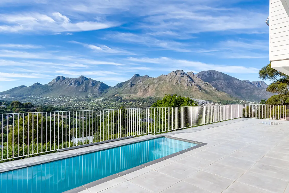 Perfect Hideaways real estate property: A patio with a pool, featuring views of the Hout Bay area and surrounding mountains. The Berg Manor and Villas, Hout Bay.