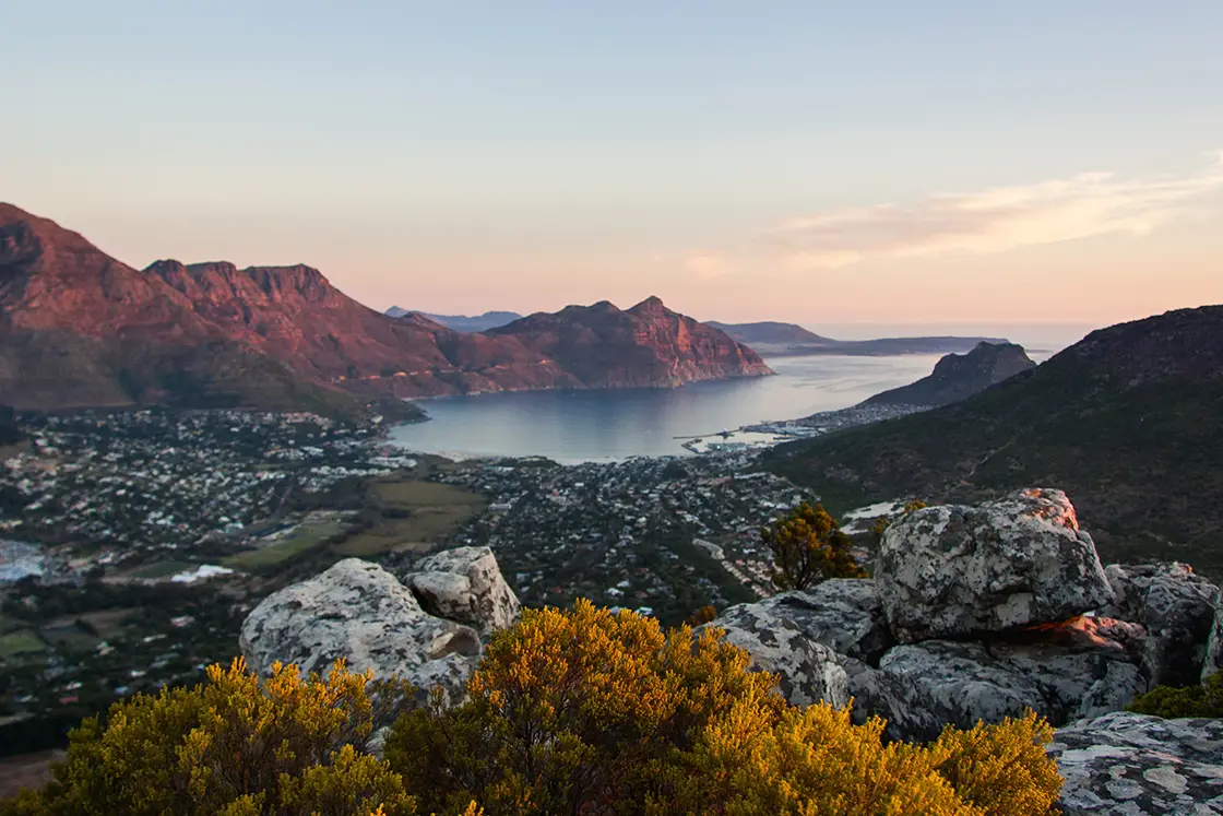 Perfect Hideaways real estate property: A scenic mountain view during sunset, featuring the famous Chapmans Peak, and mountains surrounding the town of Hout Bay. The Berg Manor and Villas, Hout Bay.