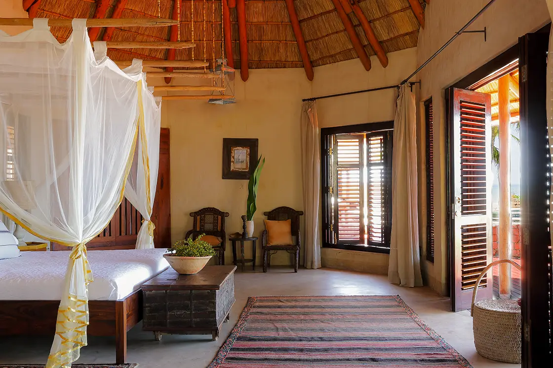 Perfect Hideaways real estate property: A spacious bedroom area, featuring Moroccan style decor and architecture. Wood shutter windows and doors provide access to the patio. Villa Tanga, Benguerra Island.