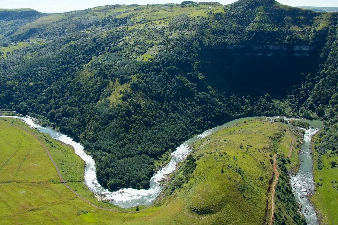 Perfect Hideaways real estate property: A winding river, showcasing farmland on one side, and lush vegetation on the other. Zulu Waters Game Reserve, Natal Midlands.