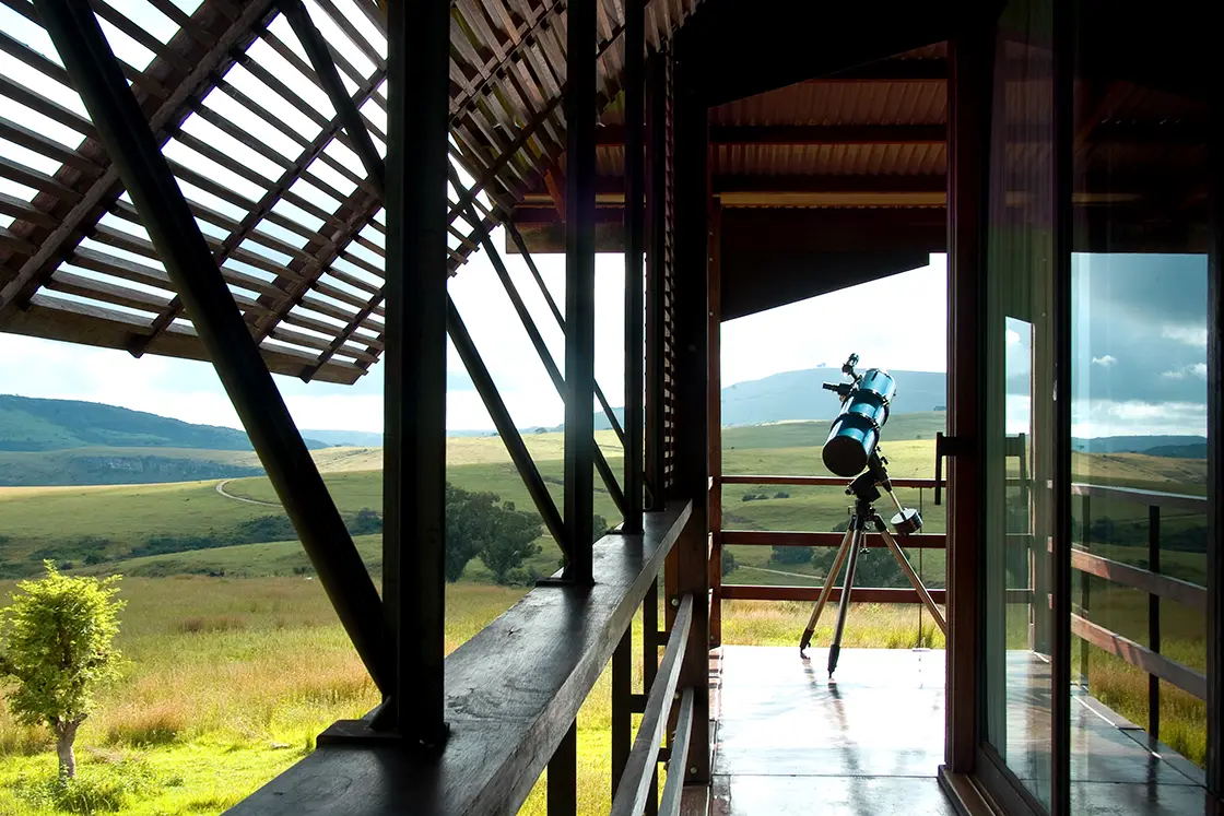 Perfect Hideaways real estate property: A wooden deck with a telescope, featuring views of the rolling hills of a game reserve in KwaZulu-Natal. Zulu Waters Game Reserve, Natal Midlands.