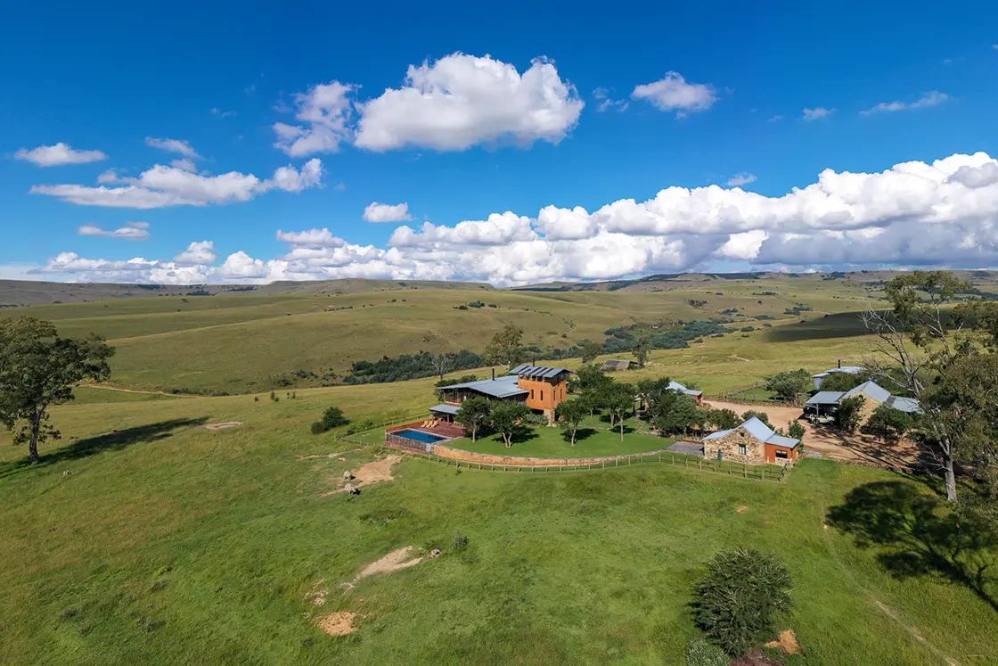 Perfect Hideaways real estate property: An aerial photograph of a game lodge atop a hill, featuring panoramic views of the rolling hills of the game reserve. Zulu Waters Game Reserve, Natal Midlands.