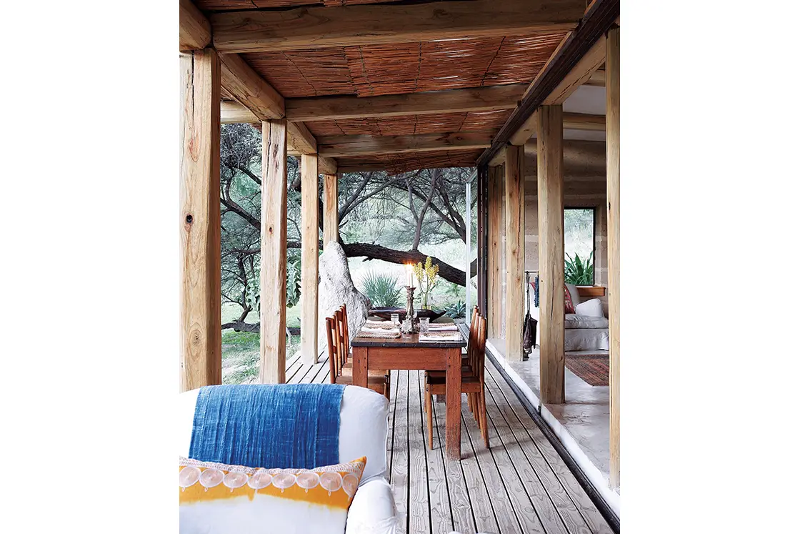 Perfect Hideaways real estate property: A pergola with natural wood support, featuring a wooden dining table. Otto House, Okavango Delta.