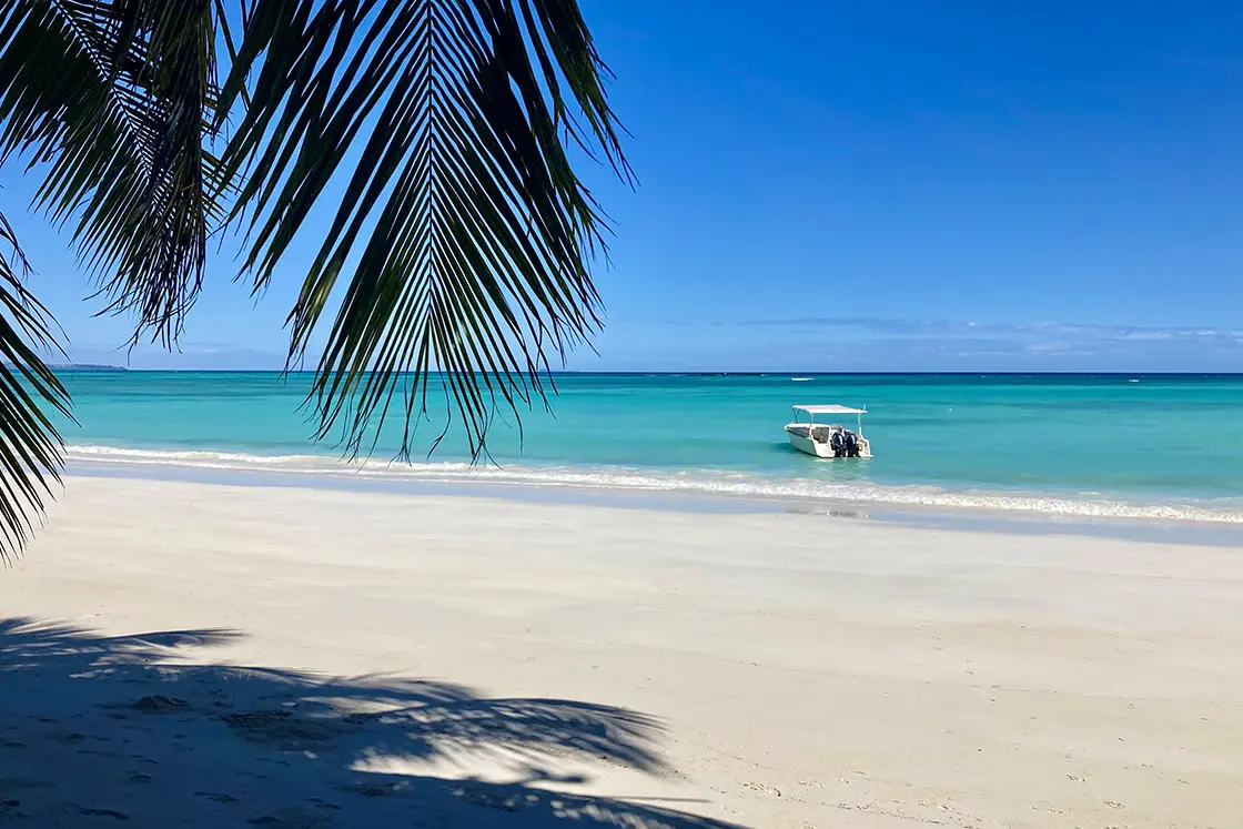 Perfect Hideaways real estate property: White sand beach with a water taxi in the shallow waters of the sea. Komba Eco Lodge, Madagascar.