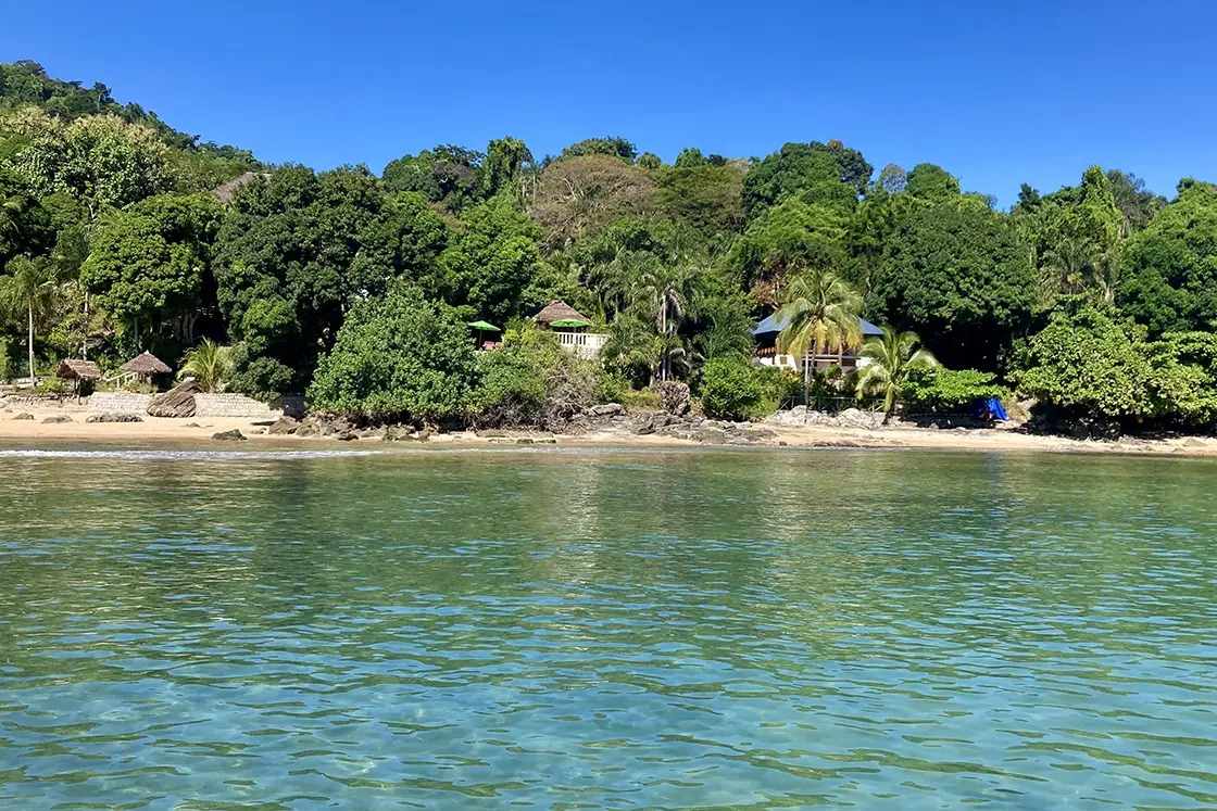 Perfect Hideaways real estate property: Clear shallow water and a beach, with an eco lodge visible between the trees. Komba Eco Lodge, Madagascar.