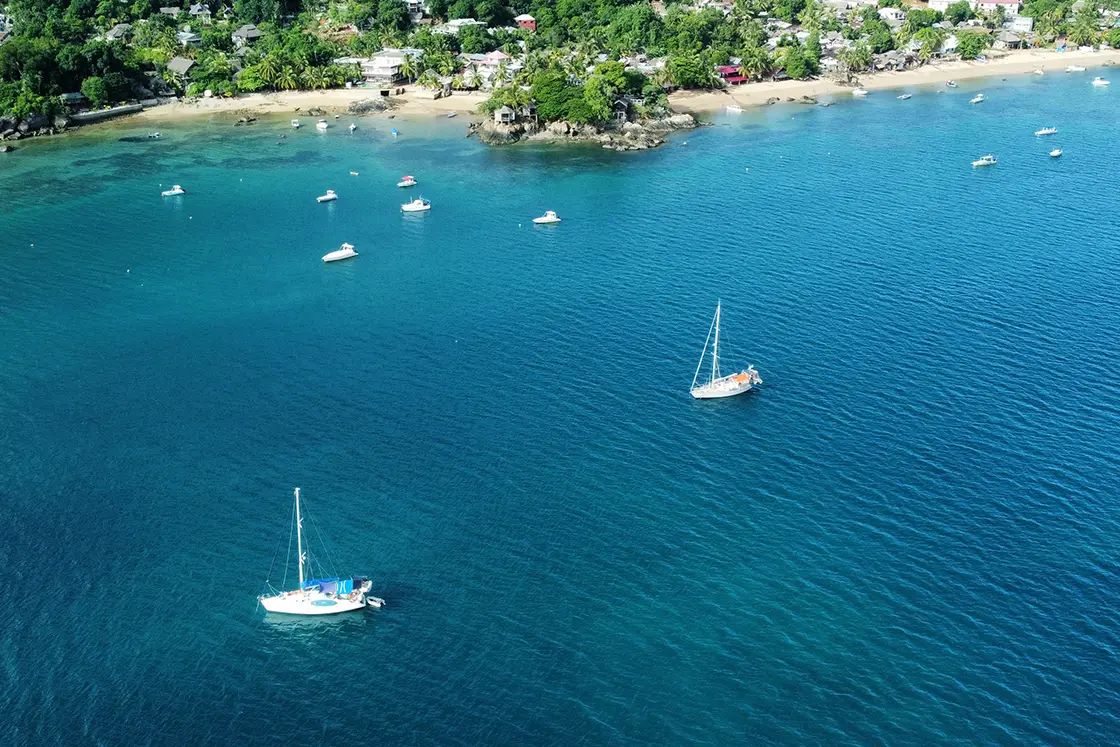 Perfect Hideaways real estate property: Fishing and recreational boats on a sunny day off the coast of a tropical island. Komba Eco Lodge, Madagascar.