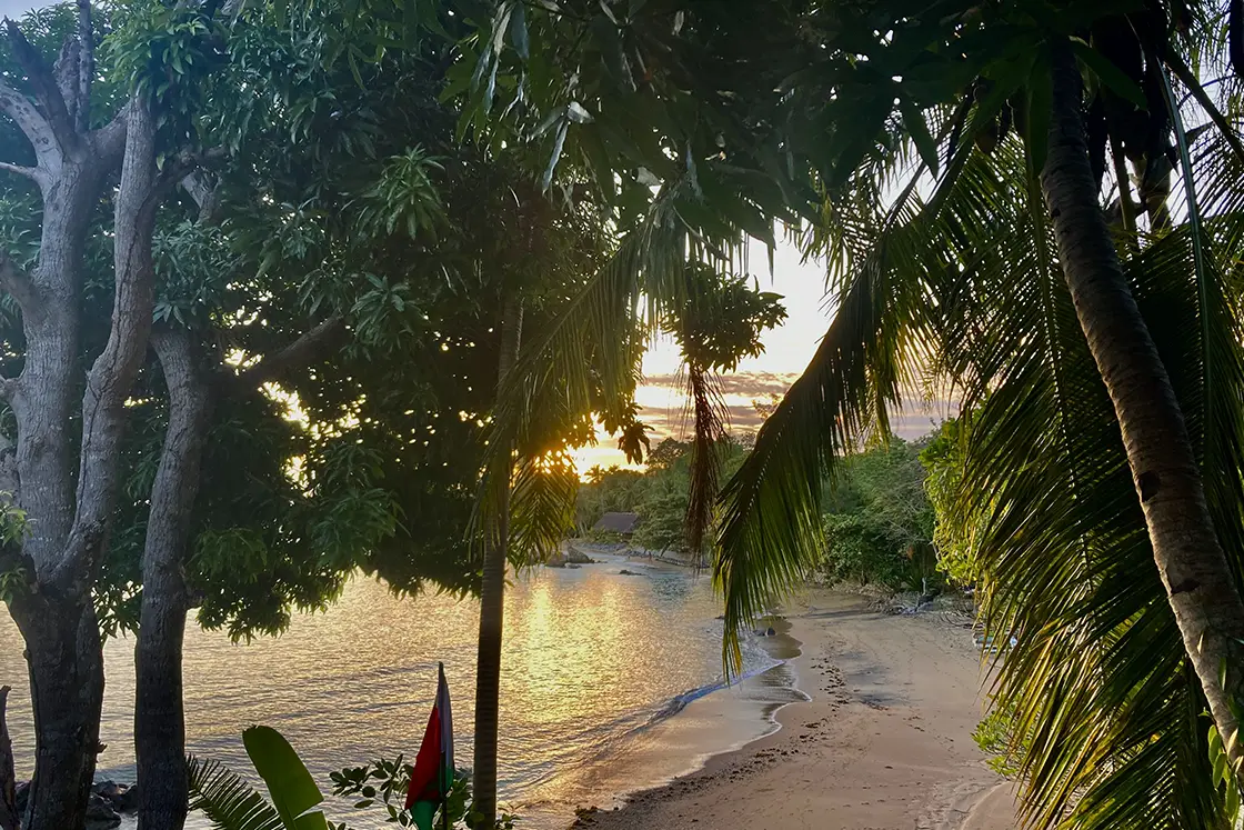 Perfect Hideaways real estate property: A tropical beach with a view of the sun setting over the island. Komba Eco Lodge, Madagascar.