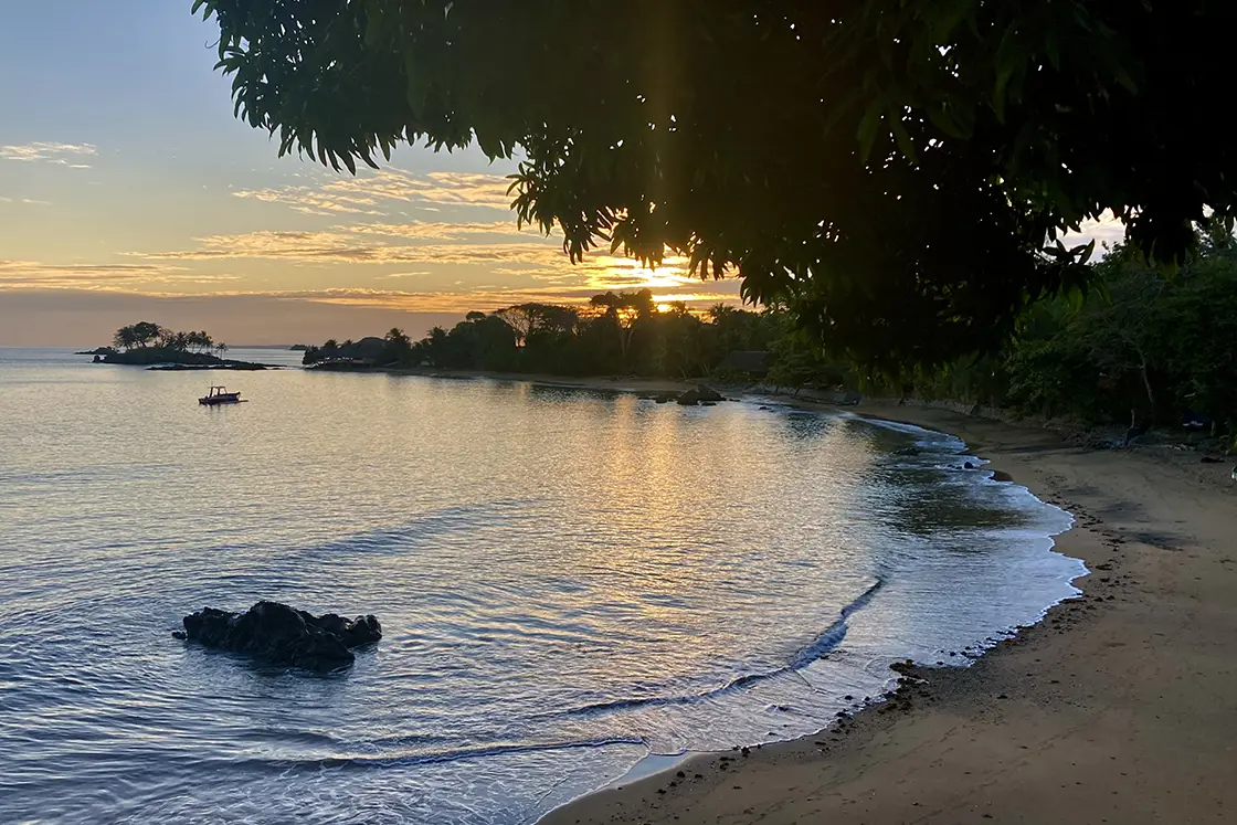 Perfect Hideaways real estate property: A scenic view of the sunset over a tropical forest and still bay. Komba Eco Lodge, Madagascar.