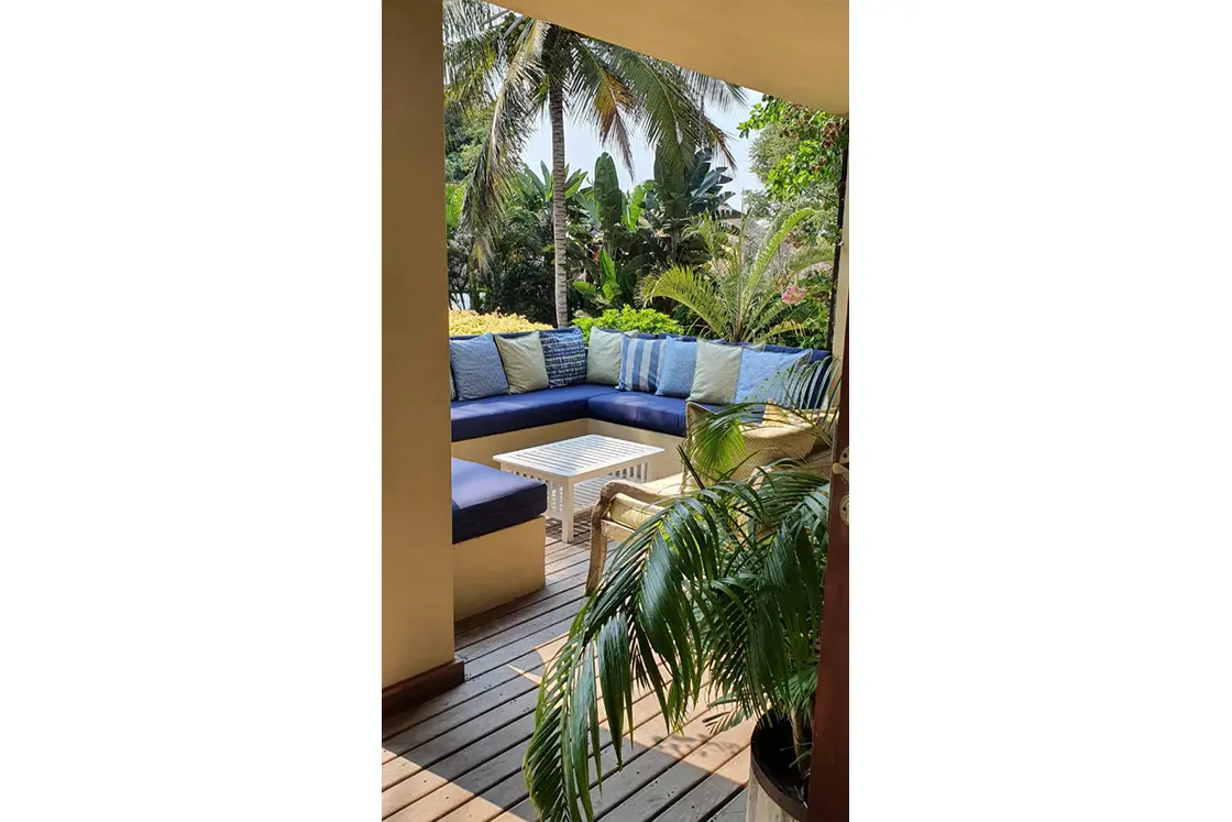 Perfect Hideaways real estate property: A "U-shaped" conversation couch with navy cushions, on the outdoor patio of the guest lodge. Villa 1b Beach House, Vilanculos.