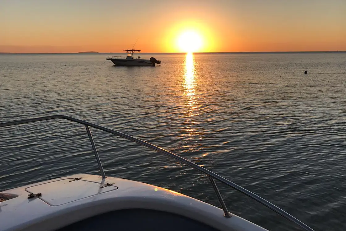 Perfect Hideaways real estate property: Two boats on calm seas, showcasing the Mozambican sunset. Villa 1b Beach House, Vilanculos.