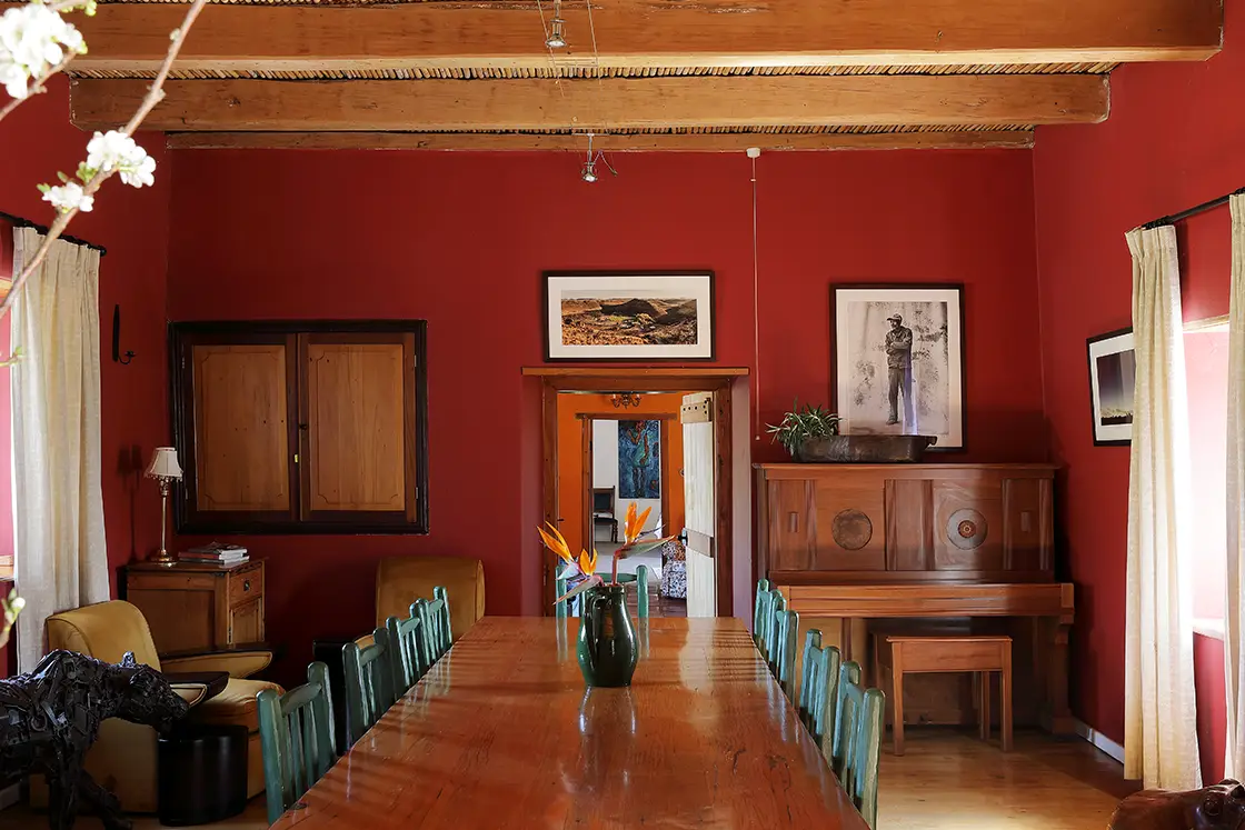 Perfect Hideaways real estate property: Dining room with red walls, long dining table, animal statues, and farm style decor. Zeekoegat Farm in Riversdale.