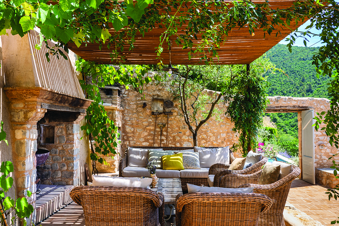 Perfect Hideaways real estate property: An outdoor fireplace surrounded by comfortable wicker seating and a low table. Casa Di Led in Spoleto.