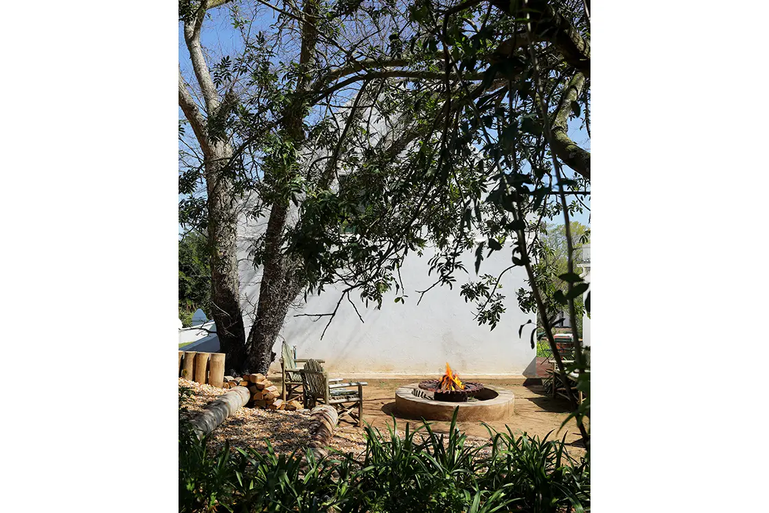 Perfect Hideaways real estate property: Outdoor fireplace and garden with seating near the historic national-monument house. Garden Route. Zeekoegat Farm in Riversdale.