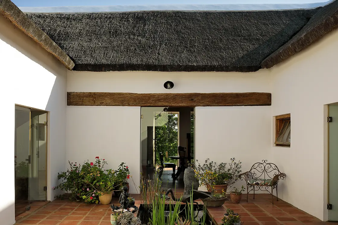 Perfect Hideaways real estate property: A central courtyard is featured in the Cape-Dutch style. A rectangular pond in the center, with small decorative plants. Zeekoegat Farm in Riversdale.