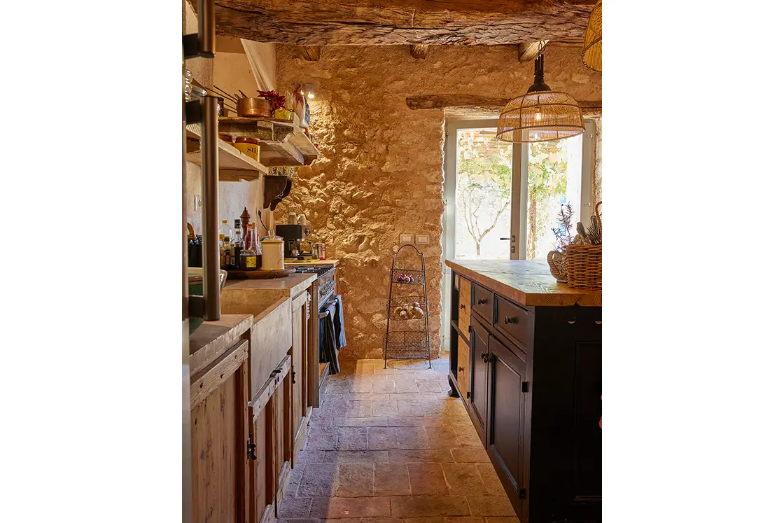 Perfect Hideaways real estate property: A rustic kitchen area with a central island and decorative lighting. Fully stocked kitchen. Casa Di Led in Spoleto.