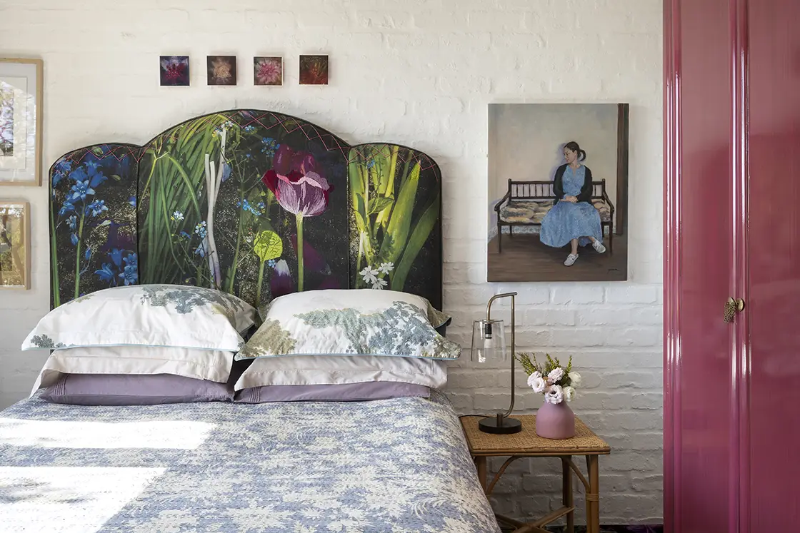 Perfect Hideaways real estate property: A bedroom with a blue patterned double bed, and a forest tapestry headboard against a white brick wall. Full length purple cupboard. Barncroft in Napier.