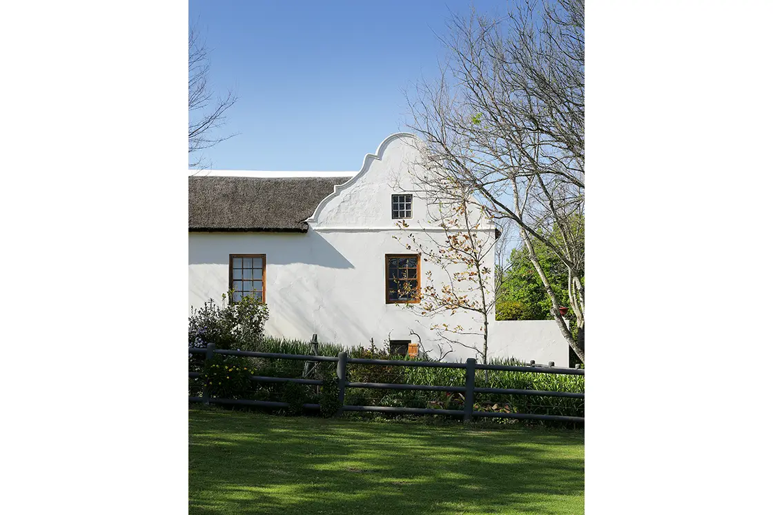 Perfect Hideaways real estate property: A homestead in the Cape-Dutch style, with a lawn bordered by a garden fence. Garden Route. Zeekoegat Farm in Riversdale.