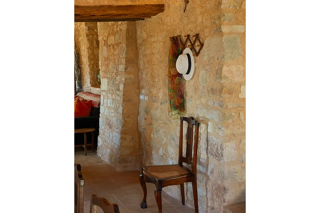 Perfect Hideaways real estate property: A natural stone hallway leading into the living area, and a hat rack with a stylish Italian hat, and sheer scarf. Casa Di Led in Spoleto.