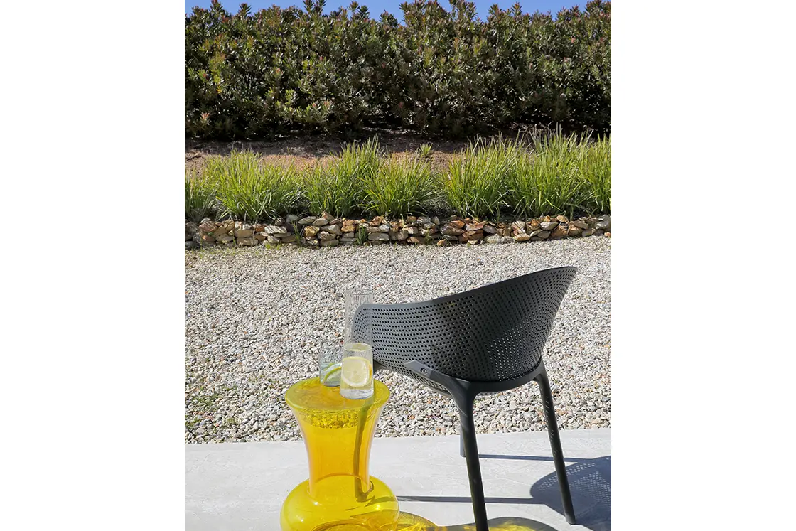 Perfect Hideaways real estate property: A grey chair beside a refreshing glass of lemonade on a sunny patio overlooking the garden. HaesFarm in Stanford.