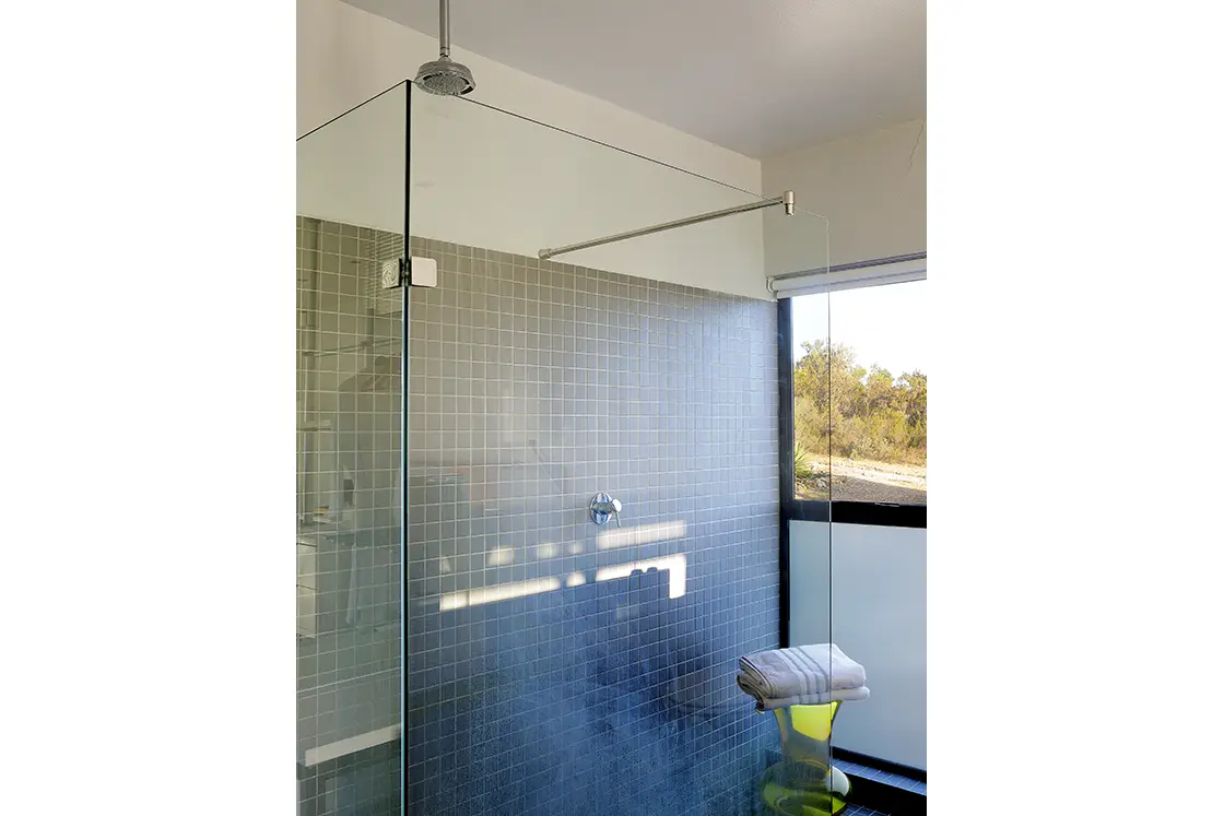 Perfect Hideaways real estate property: A modern bathroom featuring a glass shower enclosure and a window looking out at landscapes. HaesFarm in Stanford.