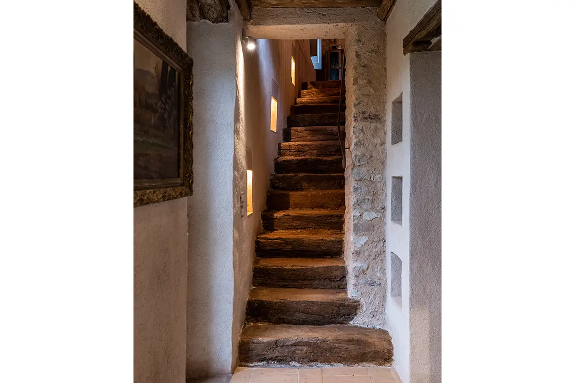 Perfect Hideaways real estate property: Natural wooden stairs leading from the limewash hallway to the floor above. Decorative alcoves line the passage. Casa Di Led in Spoleto.