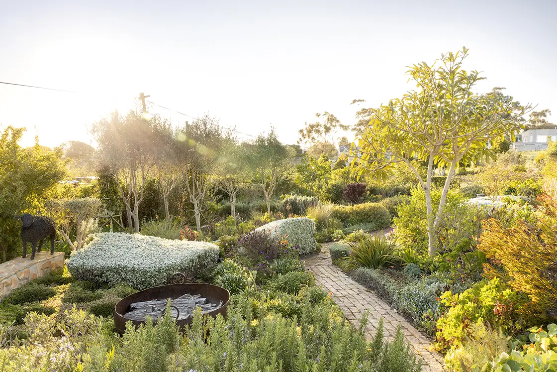 Perfect Hideaways real estate property: A cobbled pathway through the carefully curated garden, which leads to the contemporary barn-style home. Barncroft in Napier.