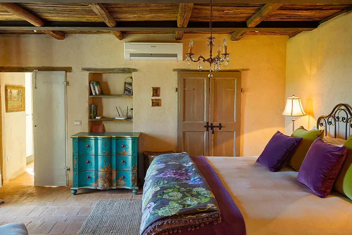 Perfect Hideaways real estate property: A bedroom with a double bed, featuring ornamental blue drawers and a wall alcove. Casa Di Led in Spoleto.