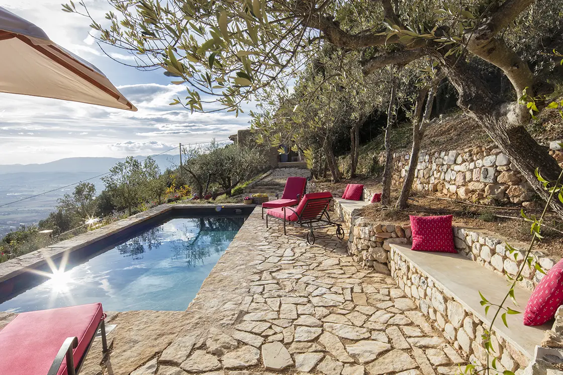 Perfect Hideaways real estate property: A pool with a natural stone deck, and pool loungers in the center of an olive grove. Expansive countryside views. Casa Di Led in Spoleto.