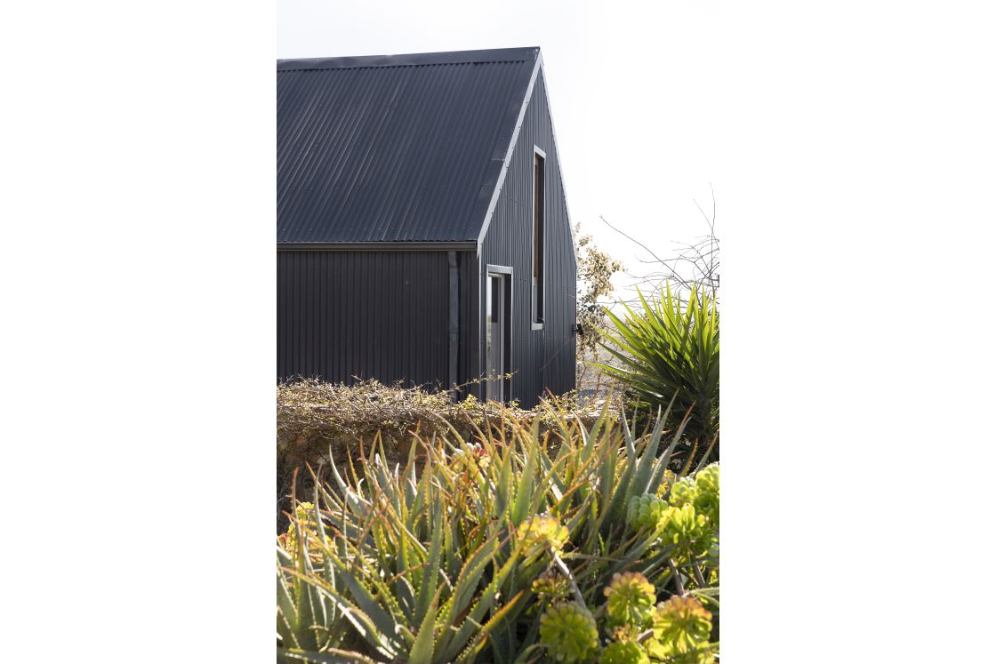 Close up view from garden. Side of house, black corrugated sheeting, barn style home. Overberg.