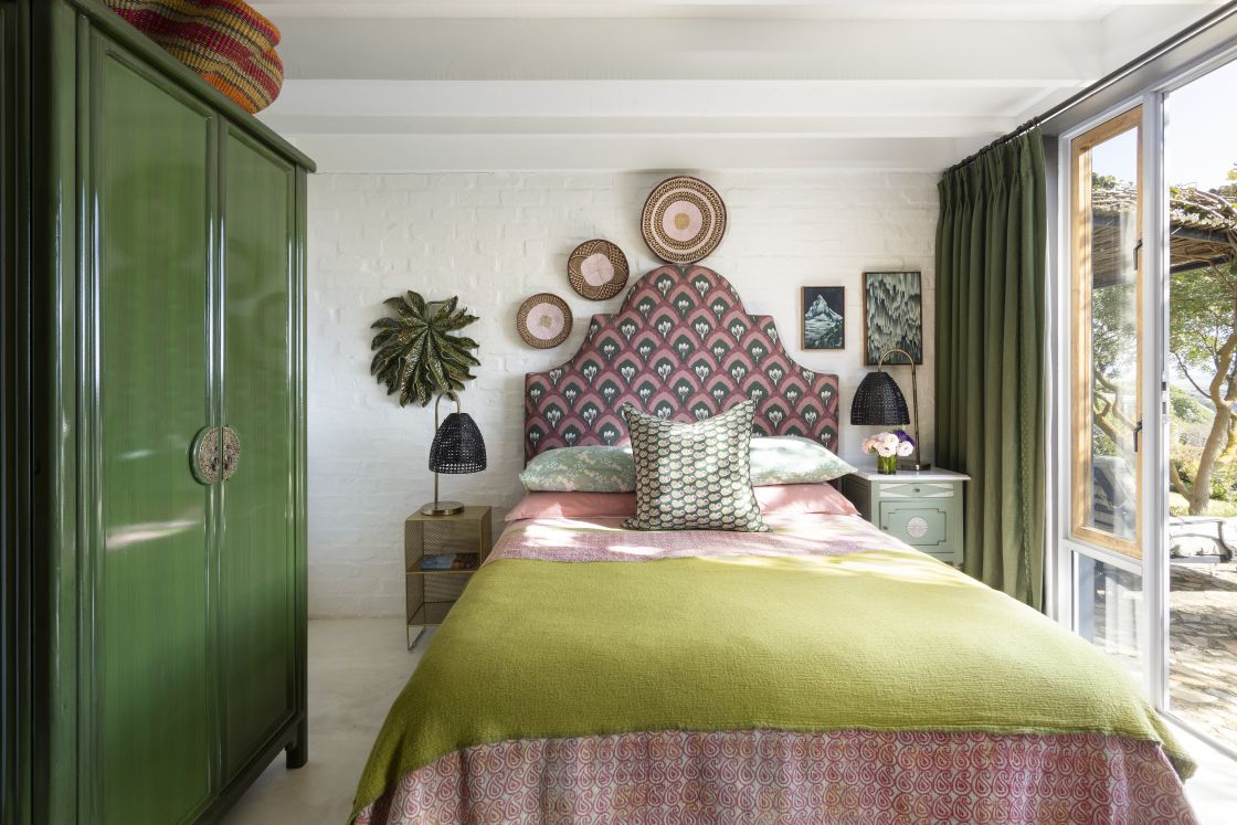 Bedroom suite with decorative pink double bed, green accent tones complement white walls. Overberg.