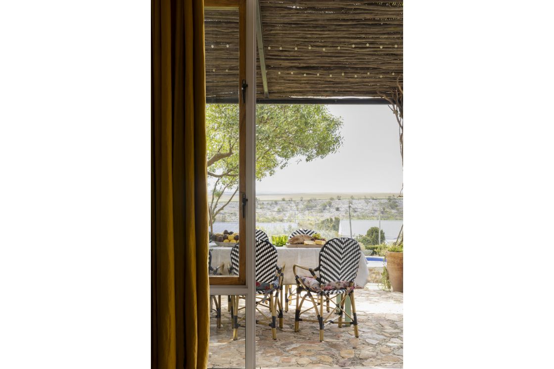 Outdoor dining area with pergola covering and zebra bistro chairs. Mustard black out curtains. Overberg