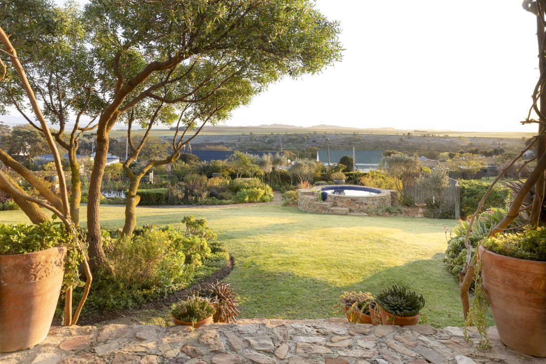 Sunset garden view from porch area. Outdoor pool with Soetmasberg mountains against backdrop. Overberg.