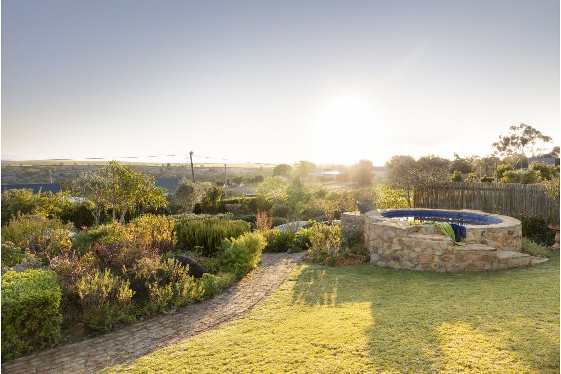 Garden path beside circular swimming pool, and meadow style garden. Overberg.