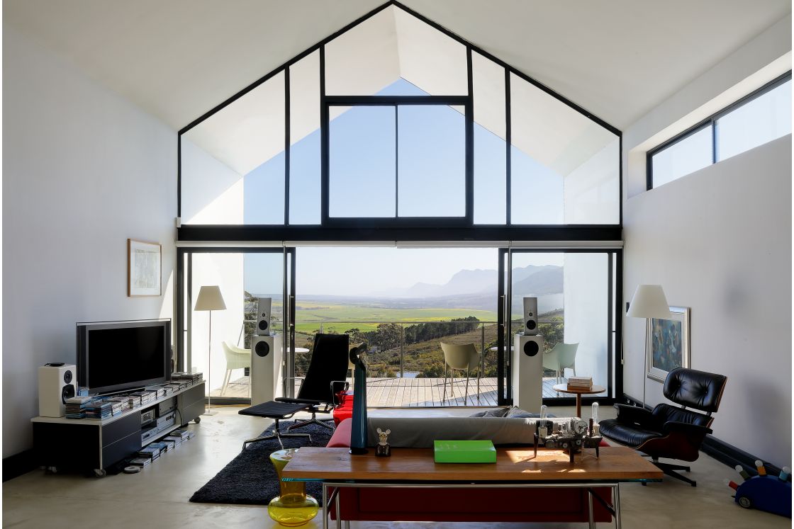 A bright living room with a large window, showcasing a valley landscape outside.