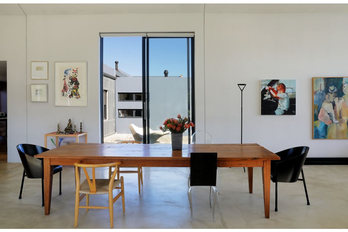 A dining room featuring a wooden table surrounded by different types of chairs.